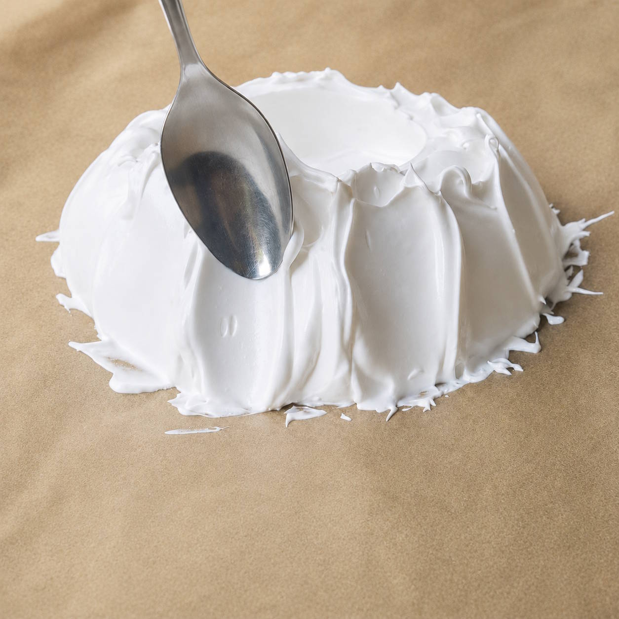 Formowanie boków bezy Pavlova łyżką Szpatułka formująca wysokie brzegi bezy Pavlova