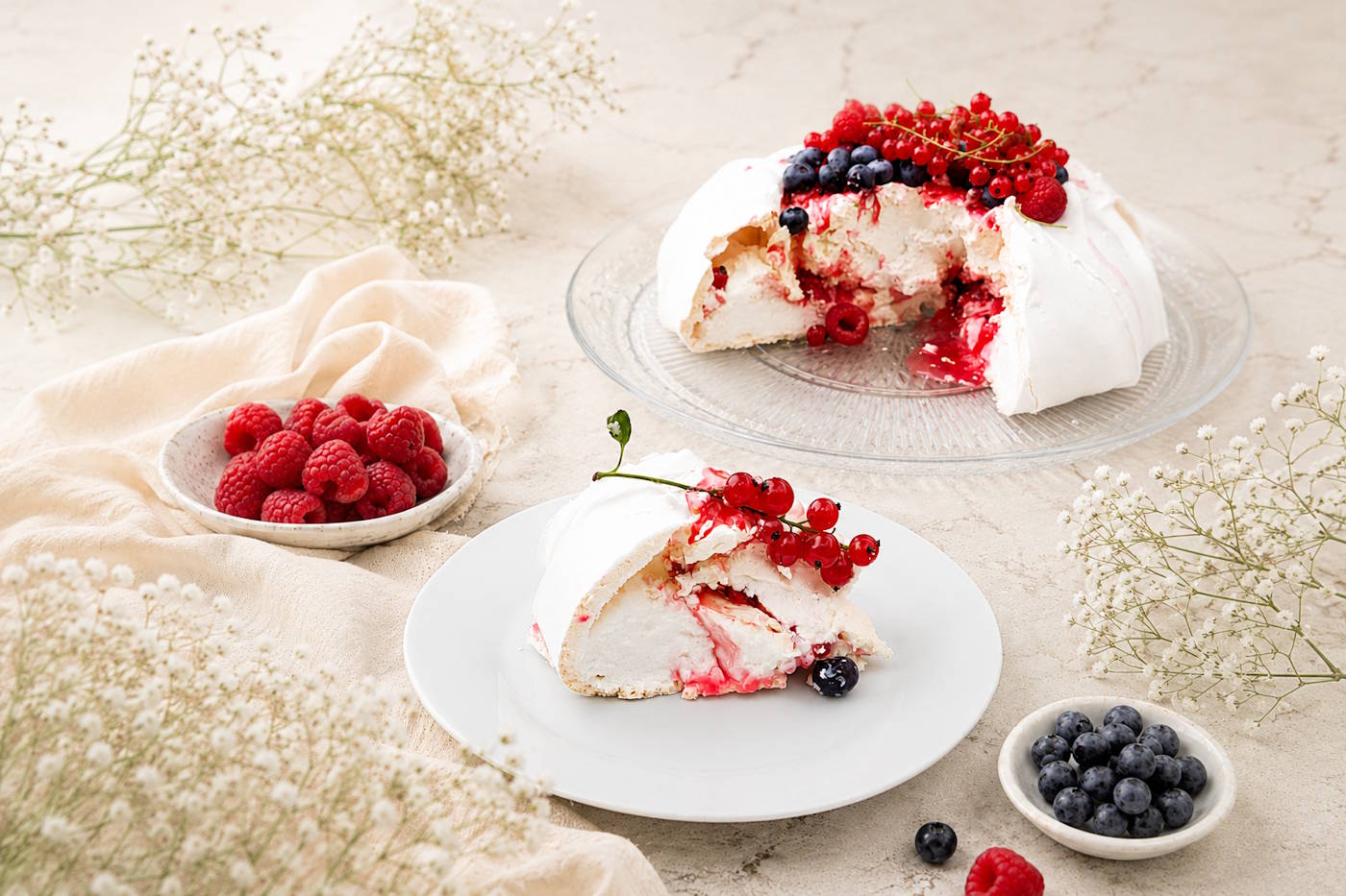 Przekrój bezy Pavlova z kremem i owocami leśnymi Przekrojona beza Pavlova z warstwą kremu, owoców leśnych i chrupiącą bezą