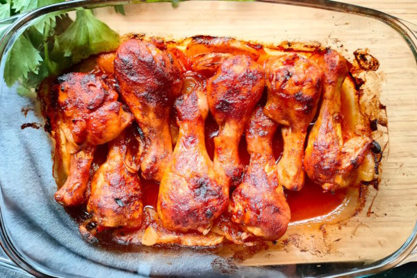 Pałki z kurczaka z ketchupem pieczone w piekarniku w naczyniu żaroodpornym.