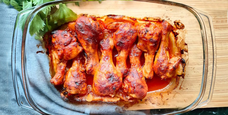 Pałki z kurczaka z ketchupem pieczone w piekarniku w naczyniu żaroodpornym.